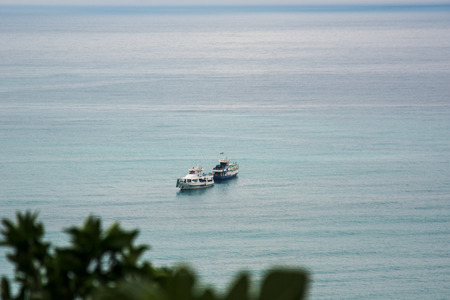 pleasure boats float across the colorful sea far behind each other.