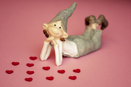 loving boy elf ceramic with hearts on coral background.