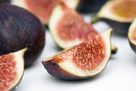 Figs whole and in pieces - fresh, juicy, tasty, sweet on a white background. macro.の写真素材