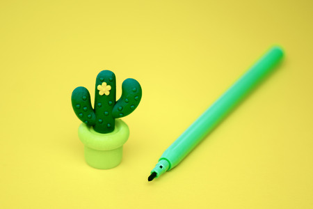 accessories for school-green marker and eraser in the form of a cactus with a flower on a yellow background. macroの写真素材