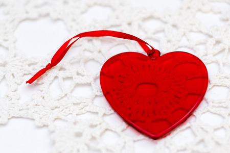 red glass transparent heart for Valentine's day on a beautiful white lace.の写真素材