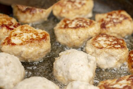 Tasty, fragrant healthy cutlets of chicken meat with spices are fried in a pan in oilの写真素材
