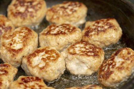 Tasty, fragrant healthy cutlets of chicken meat with spices are fried in a pan in oilの写真素材