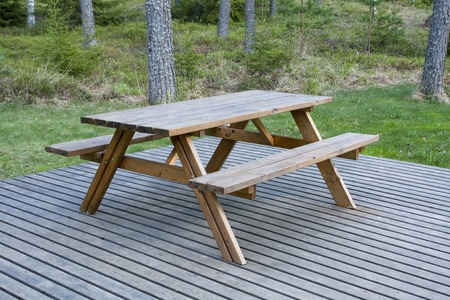 Wooden outdoor furniture on the platform in the garden
