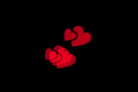 Red heart bokeh black background photo.の写真素材