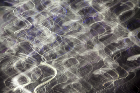 Abstract blurred light effect on a black background. Long exposure photo of moving camera.の写真素材