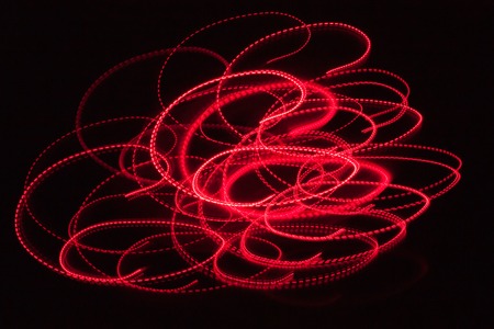 Abstract blurred red light effect on a black background. Long exposure photo of moving camera.の写真素材