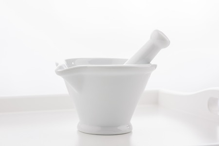 White mortar and pestles on wooden tray isolated on white background.の写真素材