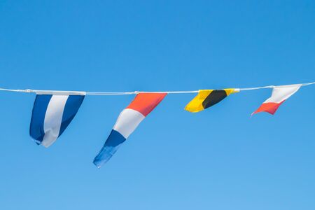 Nautical flags on the ship against blue skyの写真素材