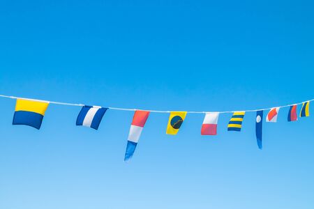 Nautical flags on the ship against blue skyの写真素材