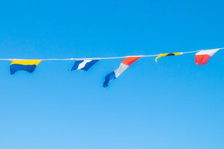 Nautical flags on the ship against blue skyの写真素材