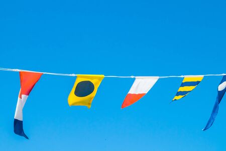 Nautical flags on the ship against blue skyの写真素材
