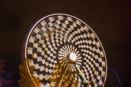 Ferris wheel in motion at the amusement park, night illumination. Long exposure.の写真素材