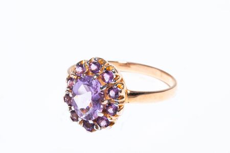 Beautiful golden ring with purple gemstone isolated on white backgroundの写真素材