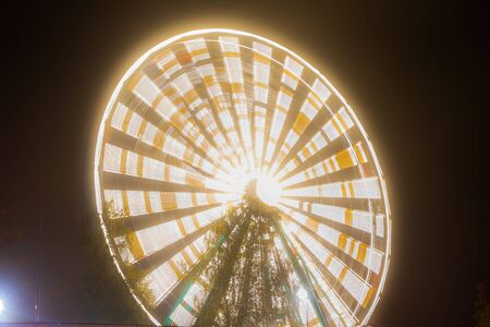 Ferris wheel in motion at the amusement park, night illumination. Long exposure.の写真素材