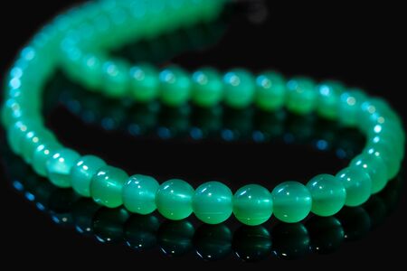 Green nephritis beads isolated on black backgroundの写真素材