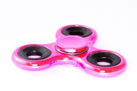 Pink spinner stress relieving toy on white backgroundの写真素材