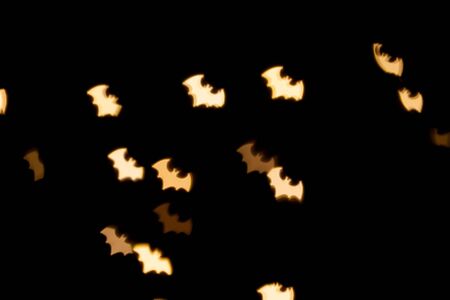 Blurred photo of defocused bokeh colorful lights in the shape of bat.