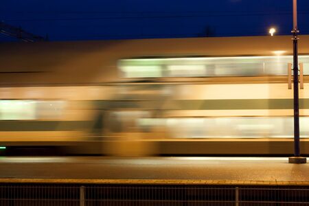 Train in motion on the station at night, long exposure photoの写真素材