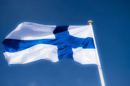 Finnish national flag on the wind against the blue sky
