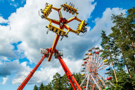 Kouvola, Finland - 14 July 2020: Rides Ferris Wheel and Loop Fighter in motion in amusement park Tykkimaki at summer sunny dayのeditorial素材