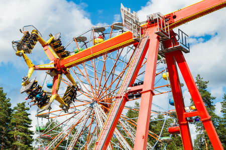 Kouvola, Finland - 14 July 2020: Rides Ferris Wheel and Loop Fighter in motion in amusement park Tykkimaki at summer sunny dayのeditorial素材