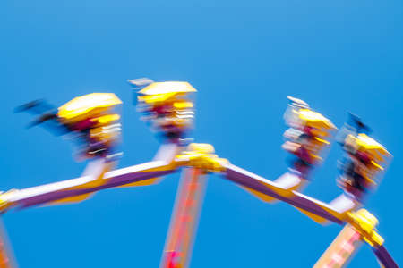 Extreme ride in motion in amusement park at sunny day