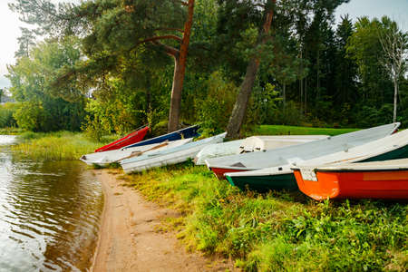 Rowing boats on coast of river at autumnの写真素材