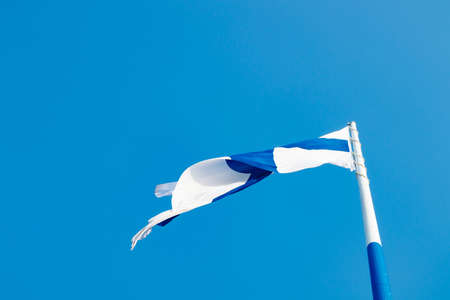 The largest Finnish flag in the world and the tallest flagpole in Europe against blue sky, Hamina, Finland. The flag pole is 100 meter high.の写真素材