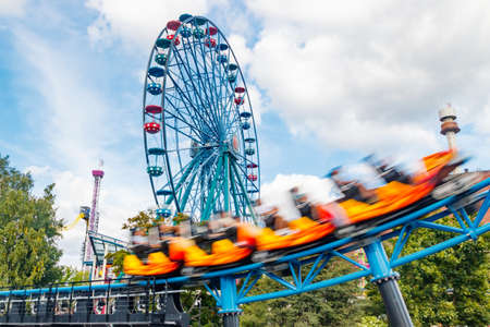 Helsinki, Finland - 23 July 2021: Linnanmaki Amusement Park, Rinkeli ferris wheel and new roller coaster Taiga in motionのeditorial素材
