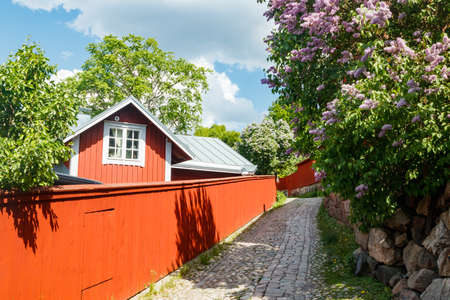 Beautiful street with old wooden houses and blooming lilac in old town of Porvooの写真素材