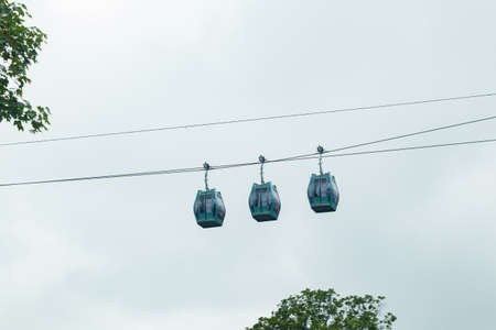 Three cable cars against cloudy sky in summer