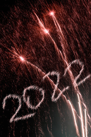 Happy New Year 2022. Sparkling burning numbers Year 2022 with firework on black background.