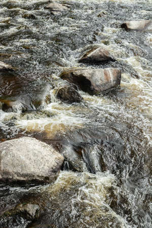 Rough river Jokelanjoki and stones in water, Kouvola, Finland.