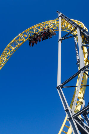 Helsinki, Finland - 24 June 2022: View of Linnanmaki amusement park with ride roller coaster Ukko in blurred motion on blue sky background.のeditorial素材