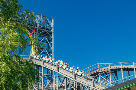 Helsinki, Finland - 24 June 2022: Ride roller coaster Vuoristorata in blurred motion on sky background in amusement park Linnanmakiのeditorial素材
