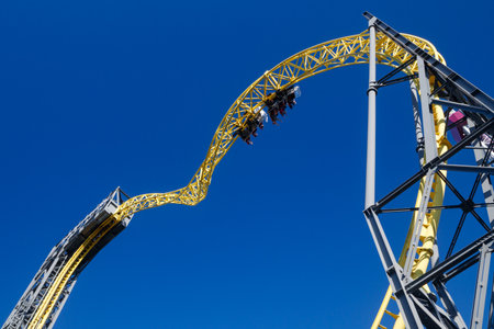 Helsinki, Finland - 24 June 2022: View of Linnanmaki amusement park with ride roller coaster Ukko in blurred motion on blue sky background.のeditorial素材