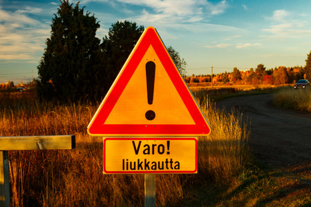 A sign, slippery conditions in Finnish language in carpet cleaning place at sunset . Sign warning of slippery conditions.の写真素材