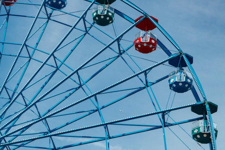 Colorful ride ferris wheel in motion in amusement park on sky background.の写真素材