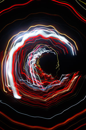 Abstract blurred colorful light effect on a black background. Long exposure photo of moving camera.の写真素材