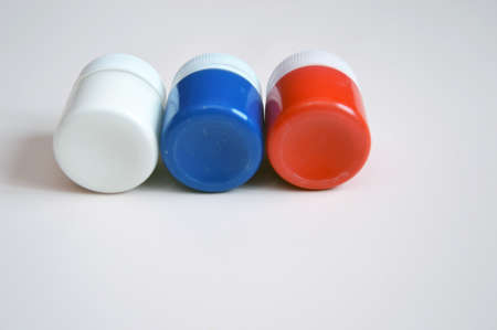 White, blue, red jars with gouache on a light background. A set of paints for drawing. Free space for text.の写真素材