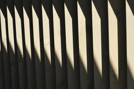 Wooden brown dark slats, boards with a bright stripe of the Sun. finishing element. abstract background.の写真素材