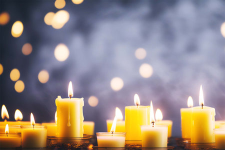 Many burning candles with a bright warm golden glow from the flame. Beautiful background.の素材
