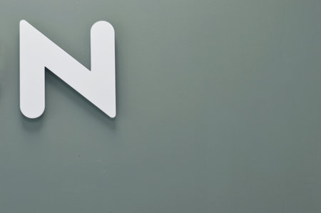 White letter N on a gray background.