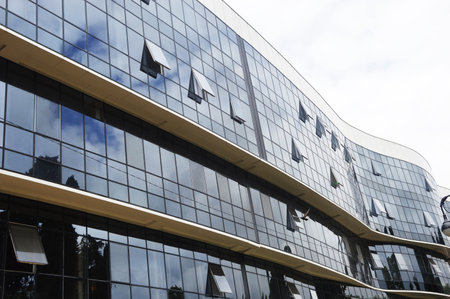 Glass facade of a modern street building with many windows. Urban architecture.