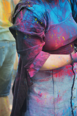 Clothes with multi-colored paint stains on a woman. Festival of colors on the street.の写真素材