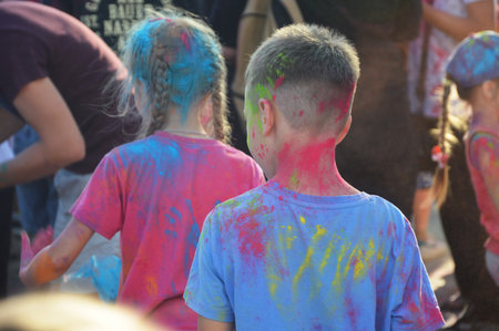Bright colored spots of powder paint on children's clothes. Street Festival of Colors.