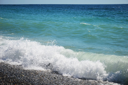 Sea wave with white foam on a sunny day.
