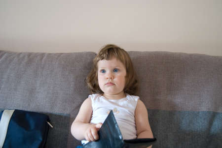 Tte baby girl is opening purse and take banks cardの写真素材