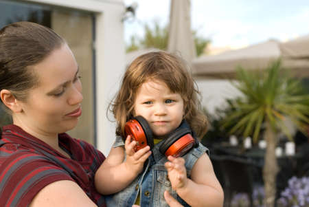 The little girl  listen music with her mother in park